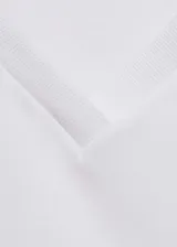 Camiseta blanca de algodón regenerativo, con cuello pico y manga corta.