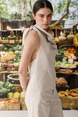 Top halter color beige de lurex con cuello drapeado y espalda descubierta. Se ata al cuello con lazos.