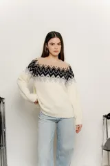 Sweater de punto color crudo con diseño geométrico en negro, gris y beige en la parte superior.
