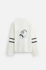 Camiseta blanca de manga larga con cuello en pico y corte relaxed fit. Presenta un estampado con el número 12 y dos rayas horizontales en color azul marino en ambas mangas.