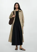 Vestido midi verde oliva con corte a la cintura y falda amplia. El cuerpo es de tejido de punto ajustado y la falda es de algodón. Tiene mangas cortas y cuello redondo.