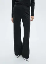 Pantalón largo acampanado negro con tejido de lúrex y cintura elástica.