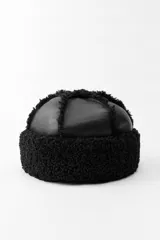 Gorro negro combinado en tejido efecto piel y efecto borreguillo.