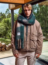 Bufanda larga con flecos, con estampado a cuadros en tonos verde, gris y beige.