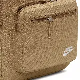 Mochila Nike Heritage Eugene color beige con logo blanco estampado en el frente. Cuenta con un compartimento principal con cierre de doble cremallera, un bolsillo frontal con cierre y un bolsillo lateral abierto. Tiene correas acolchadas ajustables y asa de mano en la parte superior.