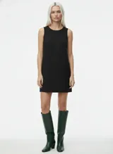 Vestido corto negro sin mangas con cuello redondo y corte recto. Confeccionado en tejido plano con mezcla de poliéster y elastano.
