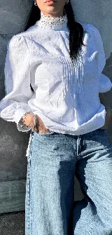 Blusa blanca de lino con cuello Galon estructurado y mangas largas abullonadas.
