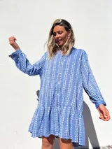 Vestido camisero corto celeste con bordado de flores blancas, corte recto y mangas largas.