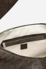 Bolso de hombro color marrón oscuro fabricado en piel con acabado craquelado. Tiene un compartimento principal con cierre de cremallera y un bolsillo interior con cremallera.