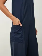 Mono largo color beige, de corte holgado, con cuello redondo y mangas cortas. Presenta bolsillos laterales y detalle de costuras verticales en el frente.