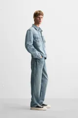 Pantalón de jean gris de corte recto, con cinco bolsillos, efecto lavado y cierre frontal con botones.