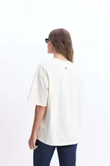 Remera blanca de corte amplio con estampado de tres rodajas de naranja y pomelo en tonos naranja y rosa.