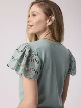 Remera blanca de poliéster y spandex con mangas cortas con volados de encaje.