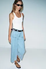 Jeans de tiro alto con corte wide leg cropped, confeccionados en denim de lavado claro. Presentan costuras marcadas en el frente, bolsillos de plastrón delanteros y cierre frontal con cremallera y botón.