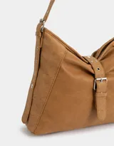Cartera hobo color marrón claro de cuerina con correa regulable y hebilla decorativa frontal.