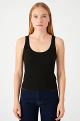 Musculosa negra sin mangas de poliéster, corte holgado y cuello profundo.