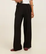 Pantalón de vestir negro, de corte wide leg, con cintura alta, bolsillos laterales y traseros.