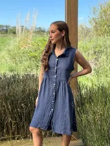 Vestido camisero azul sin mangas de lino italiano, con botones de nácar y corte a la rodilla.