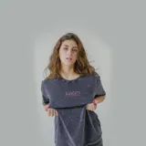 Remera gris con efecto acid wash y estampa en la espalda con la frase 'Nothing to sorry about' en color fucsia.