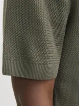 Polo de hombre color verde oliva, de punto estructurado con textura sutil, corte regular, cuello polo clásico, mangas cortas y cierre con botones.