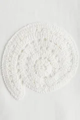 Remera blanca de algodón con cuello redondo y apliques de encaje en forma de círculos en el frente.