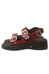 Sandalias rojas charoladas con hebillas plateadas, plataforma track negra y plantilla fucsia.
