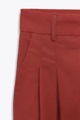 Pantalón color ladrillo de corte palazzo, con bolsillos laterales y traseros, detalle de pliegues en el frente y cierre frontal con cremallera, botón interior y gancho metálico. Confeccionado en hilatura con 21% de lino.