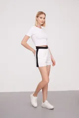 Short de lino blanco con cintura alta negra y corte recto.