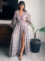 Kimono largo de seda con estampado floral en tonos verde, marrón y beige. Tiene mangas amplias y corte cruzado con lazo ajustable en la cintura.