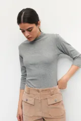 Polera de algodón blanca de cuello alto, con mangas 3/4 y costuras delicadas en las sisas.