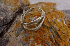 Brazalete rígido de bronce y alpaca maciza, con diseño orgánico irregular.