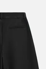 Pantalón negro de corte recto con cintura elástica, bolsillos delanteros y traseros. Cierre frontal con cremallera y botón.