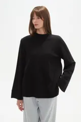 Sweater de viscosa color beige, con cuello polera, corte holgado y pespuntes decorativos en el frente.