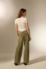 Pantalón de jean holgado y de calce alto, color verde militar, con detalles de tachas metálicas plateadas en las costuras frontales y laterales.
