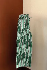 Pantalón de algodón con elástico en la cintura, estampado a rayas verticales verdes y blancas con pequeñas flores rojas.