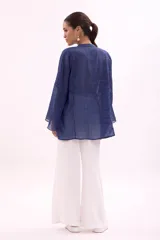 Camisa verde agua con cuello mao, abotonada al frente y mangas largas acampanadas con detalle de pinzas verticales en el frente.