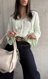Blusa verde agua con detalles de encaje, mangas largas acampanadas y lazos en el escote.