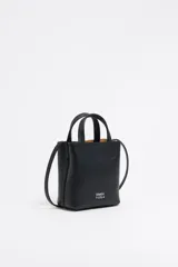 Bolso mini de piel vacuna color negro, con estructura blanda y formato vertical. Tiene doble asa corta, correa larga regulable, cierre con cinta, logo metálico BIMBA Y LOLA, acabados metálicos, bolsillo interior con cierre de cremallera e interior con logo grabado.