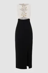 Vestido midi negro y blanco, sin mangas, con top blanco drapeado con bordados florales de tul con perlas y cuentas de vidrio doradas, falda negra con tajo lateral y corte ajustado.