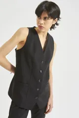 Chaleco negro cruzado con botones y bolsillos sastreros.