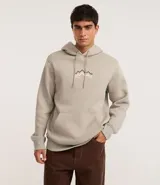 Hoodie cerrado de algodón con felpa, color beige claro, corte comfort. Presenta capucha con cordón ajustable, bolsillo canguro y puños y ruedo ajustados. Estampa minimalista de montañas en el pecho con líneas en tonos marrón, negro y rosado.