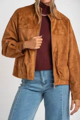 Campera tipo bomber de cuero vegano color camel, con cierre frontal y cuello alto. Presenta un calce oversize y puños ajustados con botón.