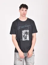 Remera gris jaspeado de manga corta con estampa rectangular con palmeras y texto en azul.