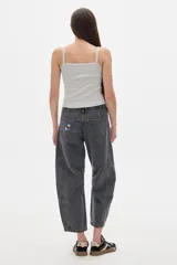 Pantalón jean slouchy de tiro medio, estilo mom, color gris oscuro con lavado suave. Presenta un bordado de estrella en el bolsillo delantero.