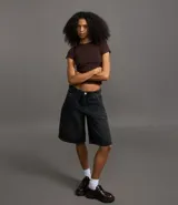 Remera negra de rib de algodón, con cuello redondo y mangas cortas. Corte ajustado y largo a la cadera.