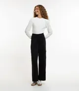 Pantalón largo negro de material sintético con cintura elástica, bolsillos laterales tipo cargo y abotonado delantero.
