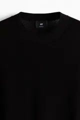 Remera negra de punto calado de algodón con cuello redondo, mangas cortas y corte estándar.