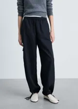 Pantalón negro de corte ancho con cintura elástica y cordón ajustable.