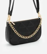 Cartera baguette pequeña color negro, con correa de hombro ajustable y cierre superior. Presenta un patrón geométrico en relieve y una cadena dorada decorativa en el frente.