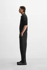 Pantalón negro de corte recto con cintura elástica ajustable con cordón, bolsillos laterales y traseros.